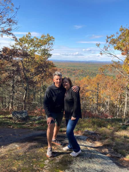 couple posed in front of autumn trees